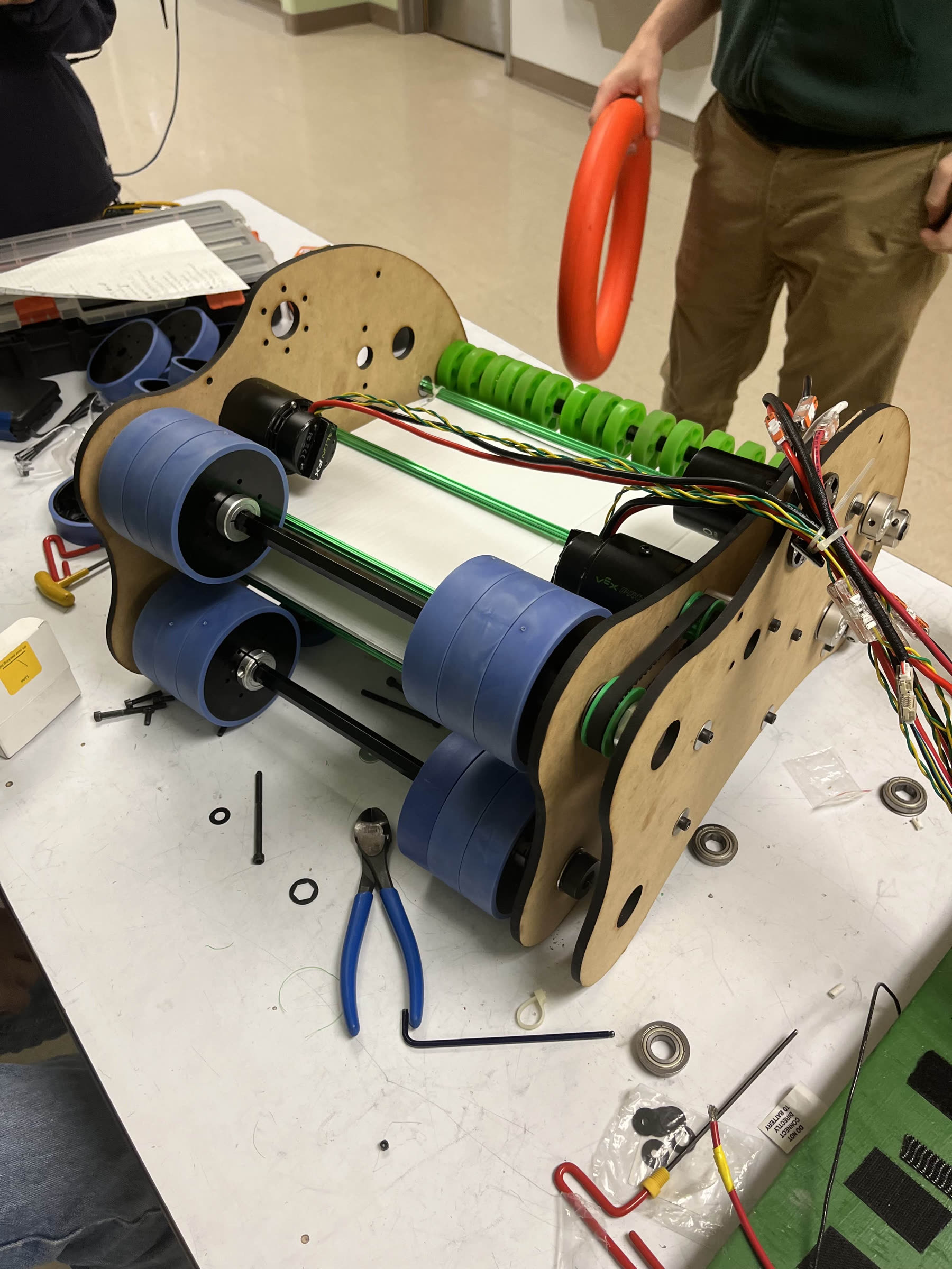 Laser-cut wood bench prototype of the note shooter/intake mechanism, with rollers and belts visible